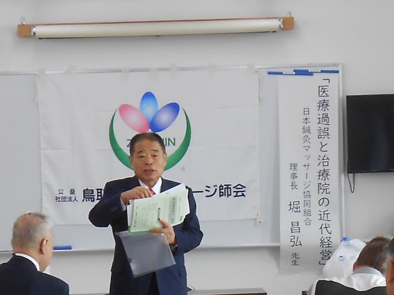 資料を持って講演する堀先生